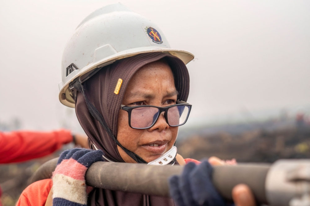 Smoke masks and motorbikes, Kalimantan mothers blaze through haze to defend burning forests