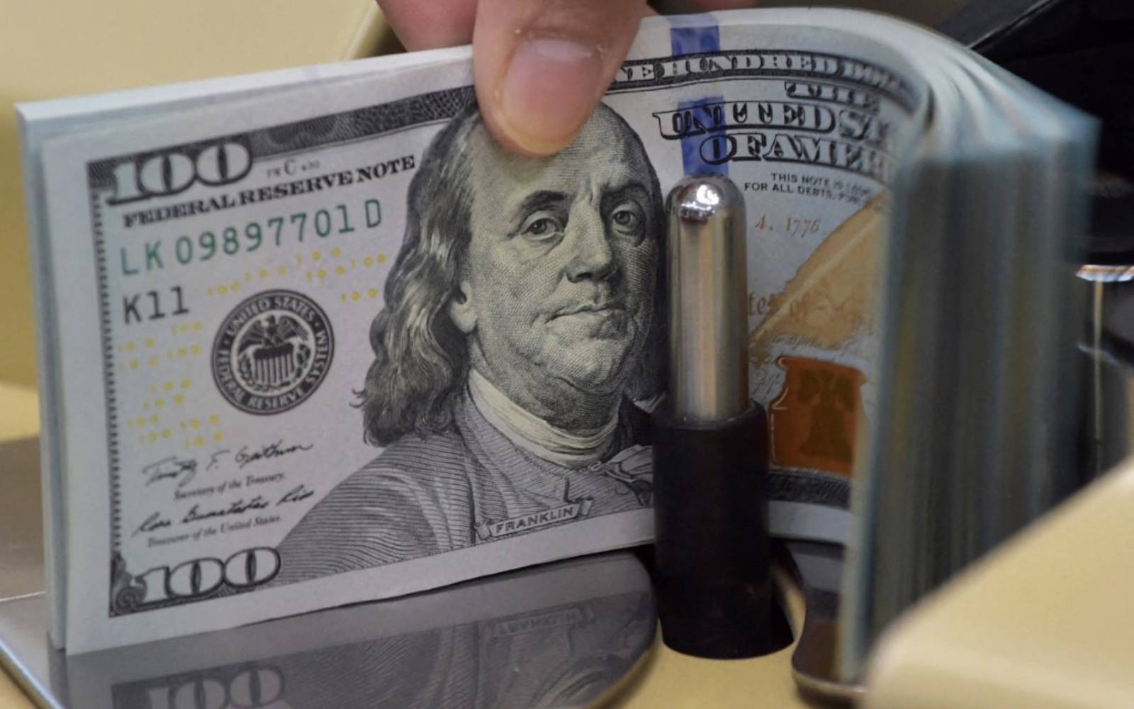 Dollar holds losses as markets await Fed minutes, speakers
