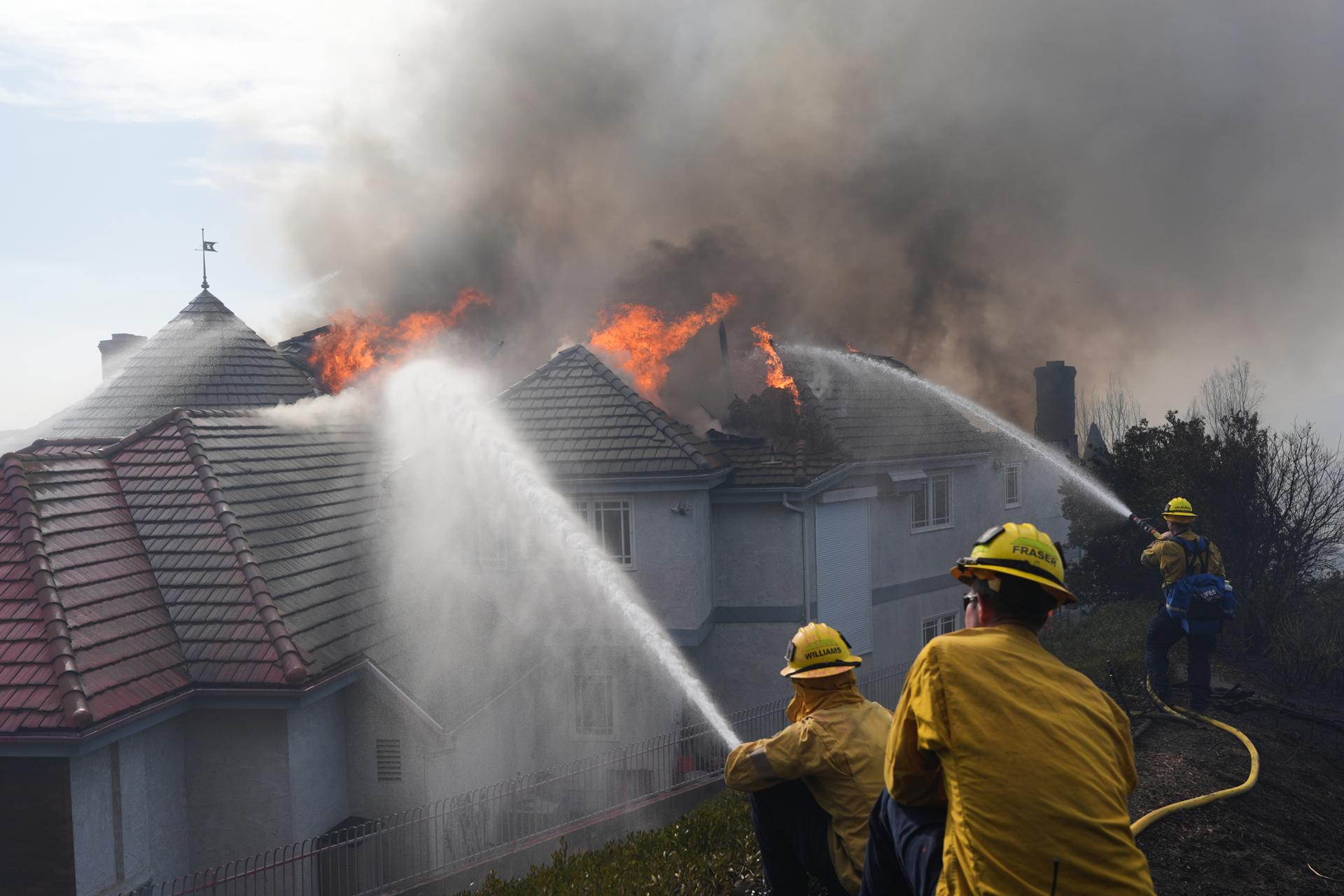 Coastal homes burn as hot winds fuel California fires