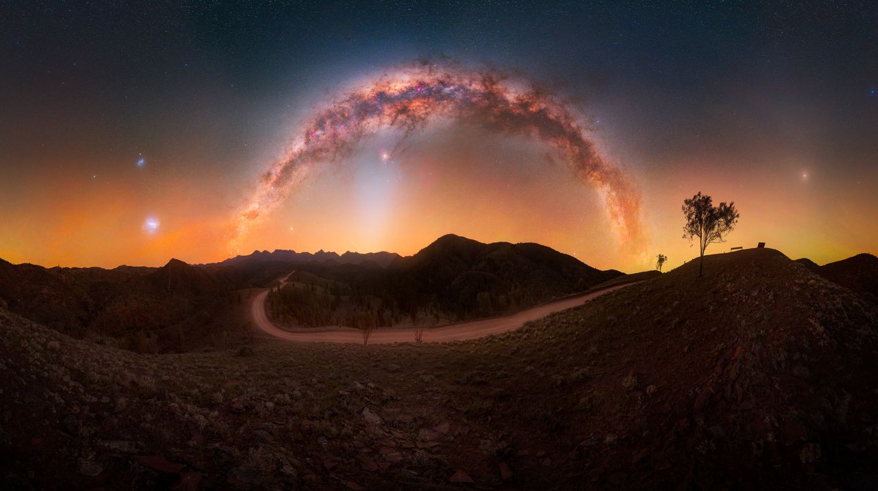 This majestic Milky Way photograph “celebrates the remarkable clarity of Australia’s dark skies, where multiple celestial phenomena can be experienced together above an iconic outback landscape”