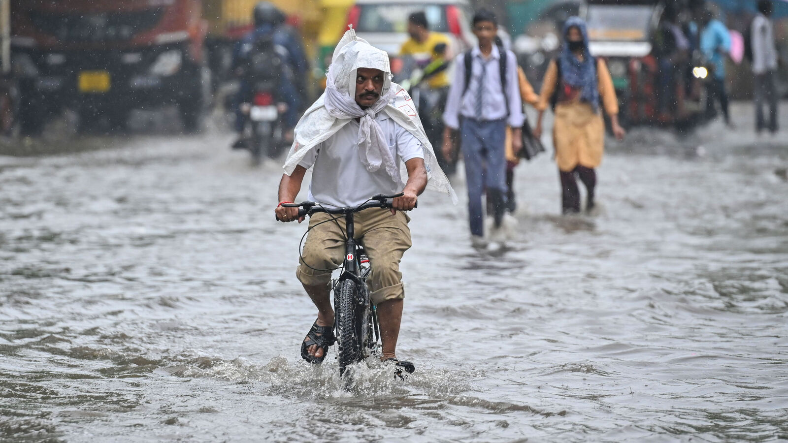 Delhi rain floods streets, disrupts traffic; locals use makeshift raft to ferry schoolchildren