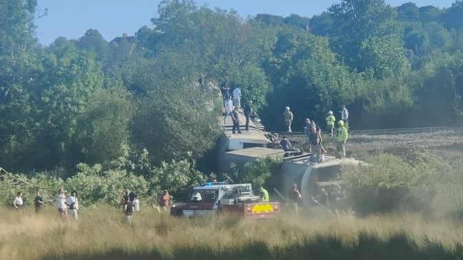 Passengers clamber out of train carriage after derailment in England
