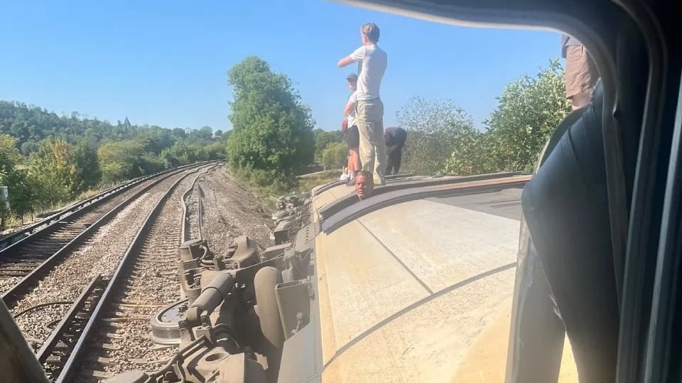Passengers clamber out of train carriage after derailment in England
