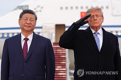 (LEAD) Trump gives Xi rare welcome at military base on eve of high-stakes summit